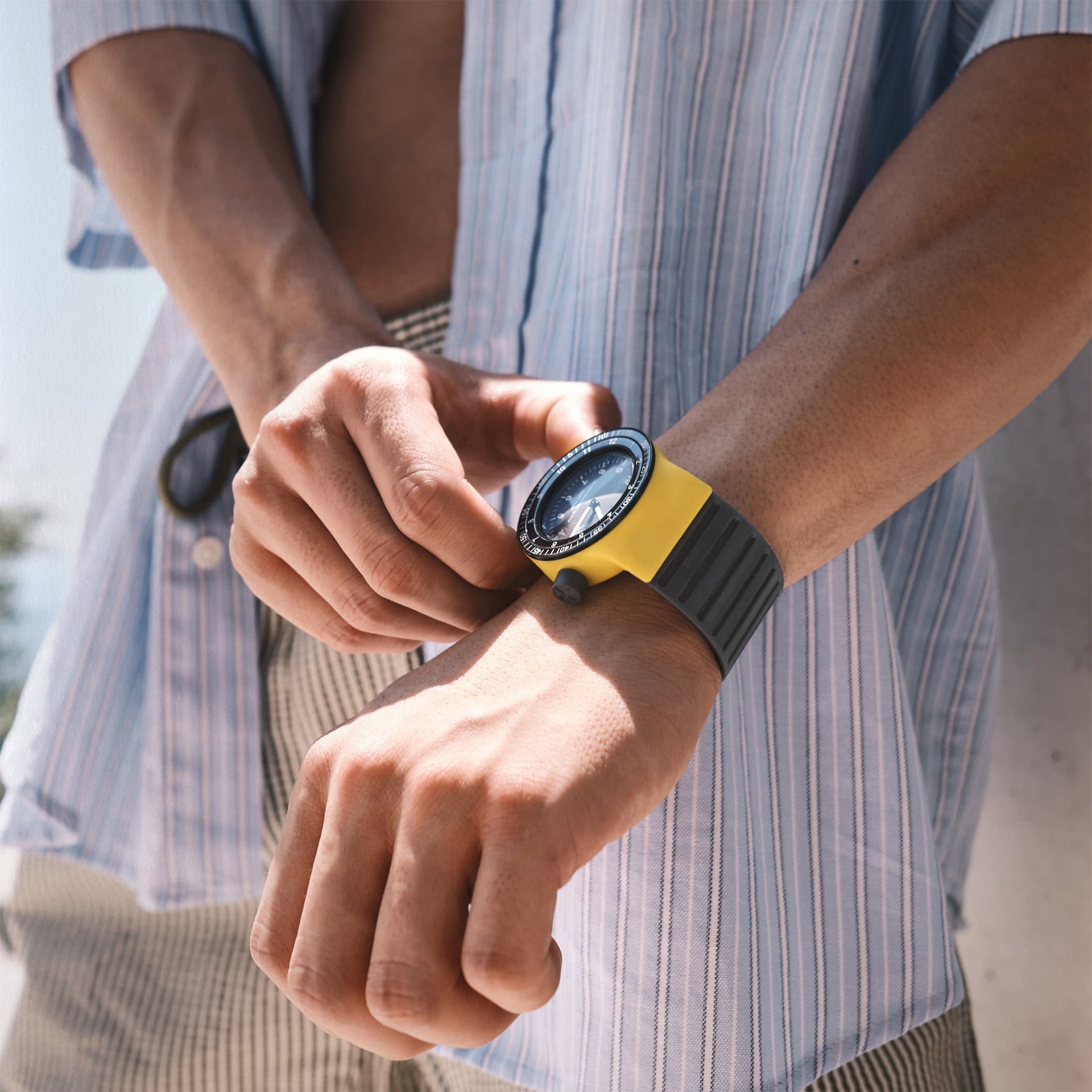 Uomo con al polso uno Sbang giallo con cinturino e corona color nero